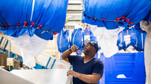 Supervisor Ron Vann waits for a bag of soiled laundry to drop at Fillmore Linen Service in North Lawndale.