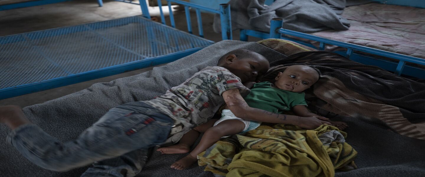 Five-year-old Tigrayan refugee Micheale Gebremariam hugs his 4-month-old sister Aden after waking up early in the morning in their shelter in Hamdayet in eastern Sudan, near the border with Ethiopia.