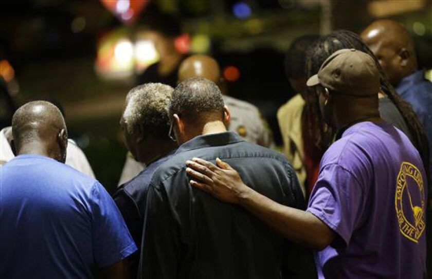 Worshippers gather to pray in a hotel parking lot across the street from the Emanuel AME Church after a shooting night in Charleston, S.C. | David Goldman/AP