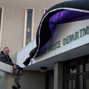 Michael Sheldrake hangs bunting outside the Wentworth station Tuesday. | Scott Olson/Getty Images