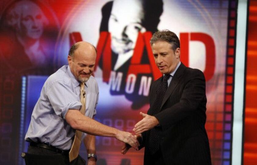 In this March 12, 2009 file photo, Jim Cramer, left, host of the CNBC “Mad Money” show, is welcomed by host Jon Stewart during an appearance on Comedy Central’s “The Daily Show with Jon Stewart” in New York. After hosting nearly 2600 editions, Stewart wil