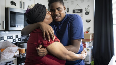 Laquita Anderson kisses her 12-year-old son, Jimele Richardson, on the cheek in the family’s South Loop home.