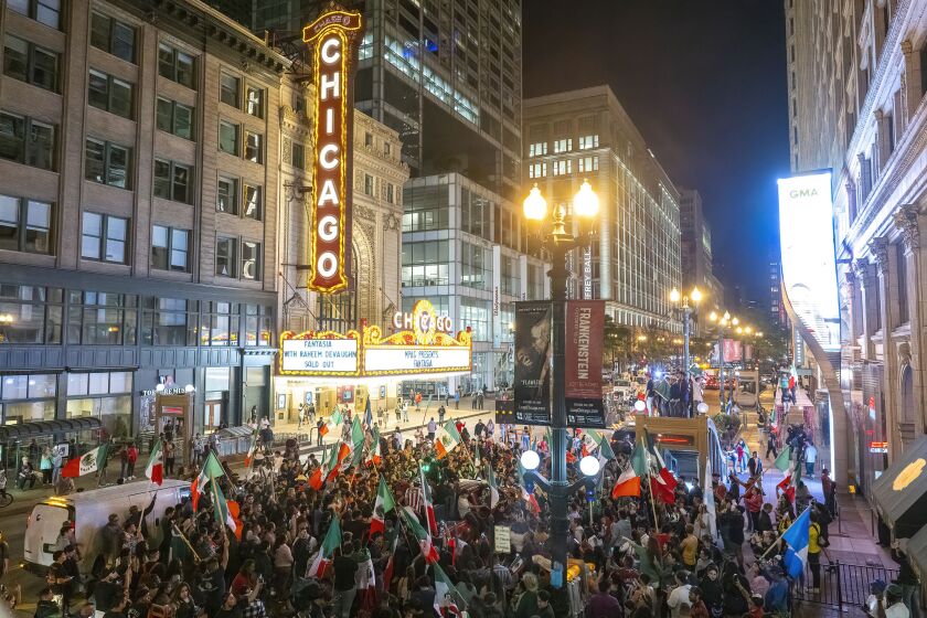 Hundreds of people gather near the Chicago Theatre as hundreds flood the Loop to celebrate Mexican Independence Day, Friday, Sept. 15, 2023.