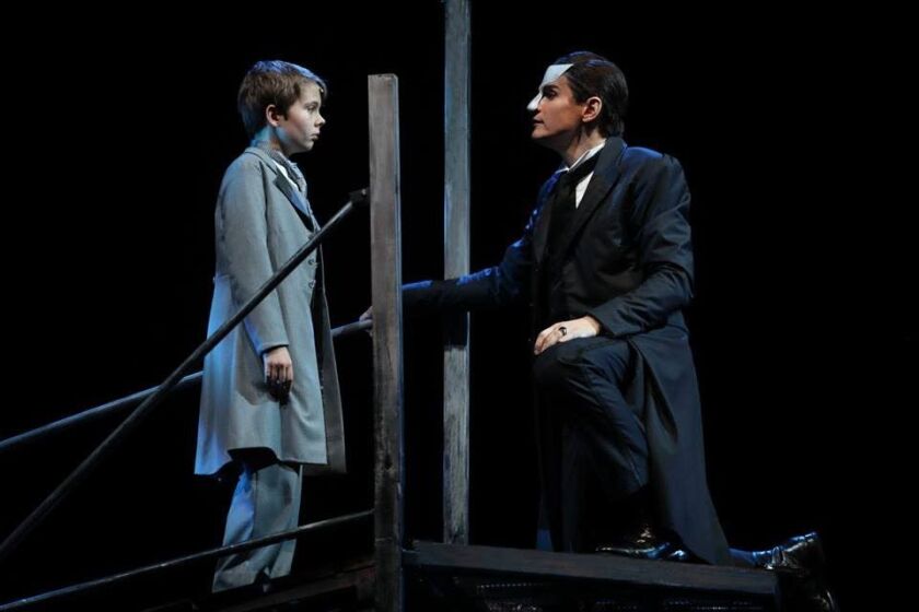 Young Gustave (Casey Lyons) is intrigued by the mysterious Phantom (Gardar Thor Cortes) in “Love Never Dies.” | Joan Marcus