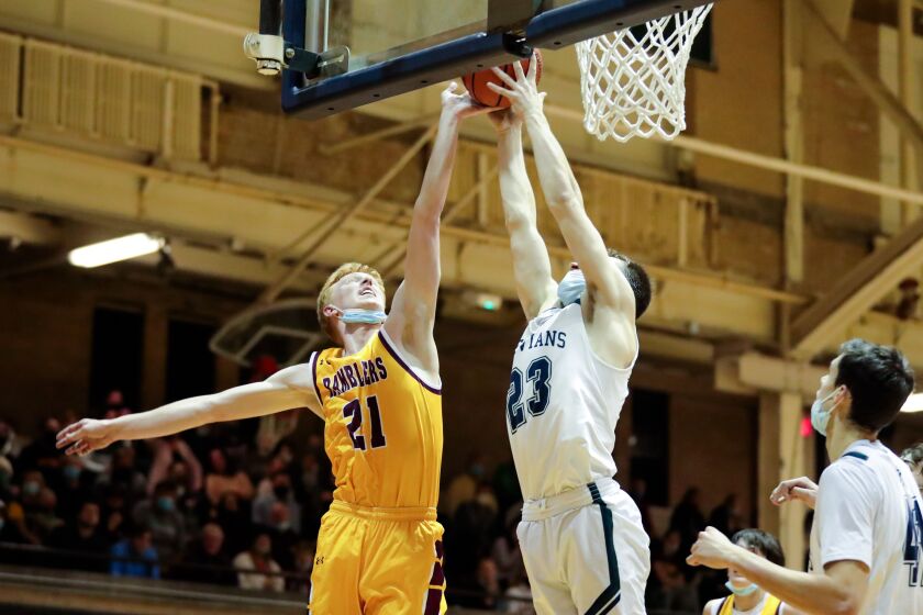 New Trier’s Jake Fiegen (23) and Loyola’s Connor Casper (21) reach for the ball.