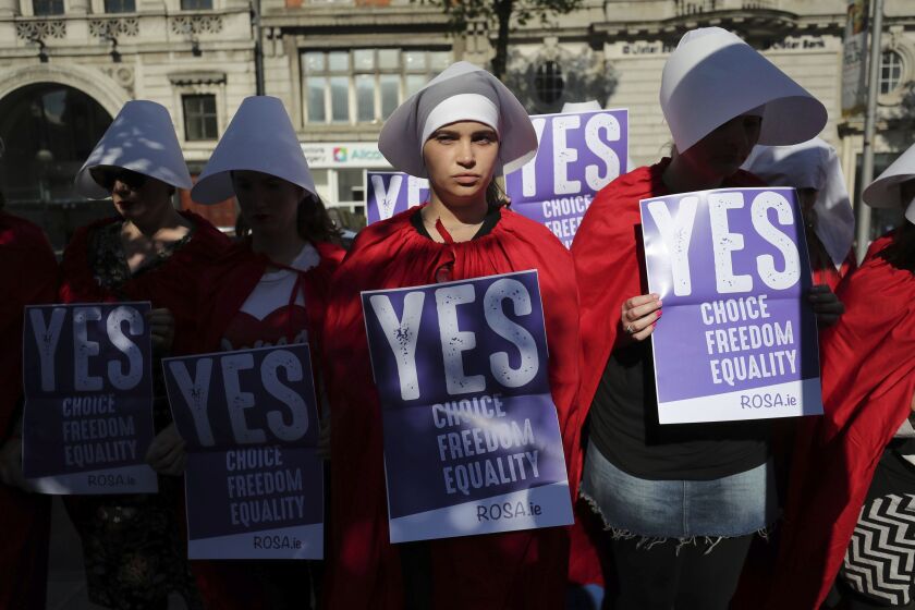 Volunteers from Reproductive rights, against Oppression, Sexism & Austerity (ROSA) dressed as characters from ‘The Handmaid’s Tale’, demonstrate in Dublin, on Wednesday, calling for a ‘Yes’ vote in Ireland’s upcoming abortion referendum on Friday. | N