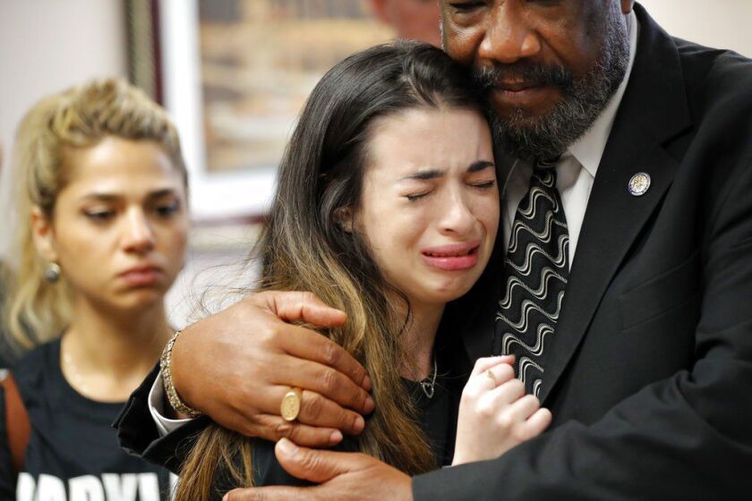 Aria Siccone, 14, a 9th-grader who survived the mass shooting at Marjory Stoneman Douglas High School, cries as she recounts her story from that day, while state Rep. Barrinton Russell comforts her. They were at the Florida state capitol on Wednesday to t