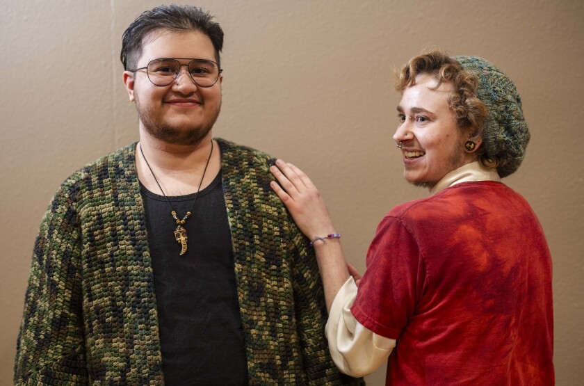 Bobby Robins (right), who is wearing a beret designed by Kimberly Porter and knitted by Robins, and Jay Shandilay, who is wearing a crocheted cardigan, smile during the 19th YarnCon at the Plumbers Union Hall in the Near West Side on Saturday.