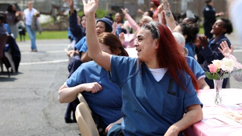 Mother Sonia Rivera raises her hand and sings at the Bloom Again event on Friday, May 8, 2026, at the Cook County Department of Corrections in Little Village.