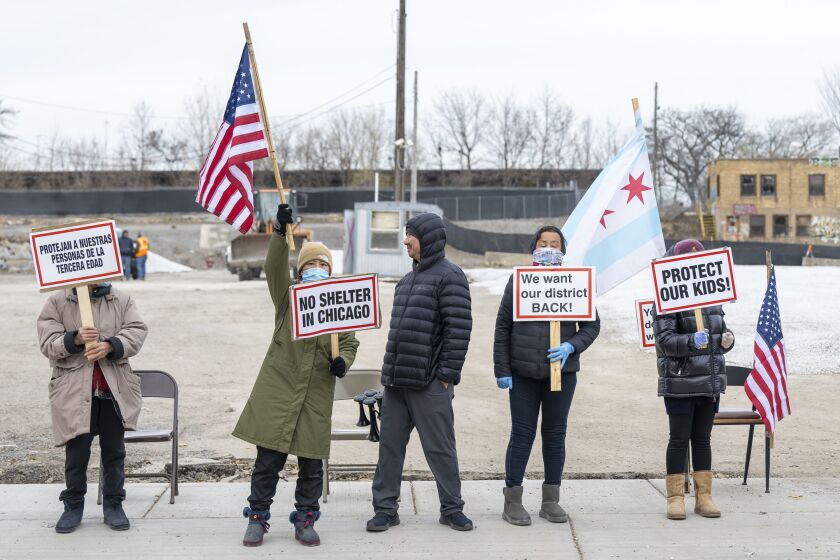 Protesters on Monday block the entrance into a planned site for a Brighton Park tent shelter that would initially house 500 migrants before expanding to 2,000. 