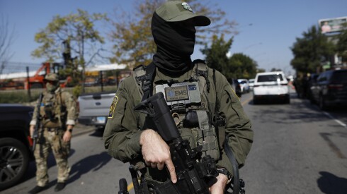 A masked U.S. Border Patrol agent on Oct. 4 in Brighton Park, where residents confronted agents at a gas station.