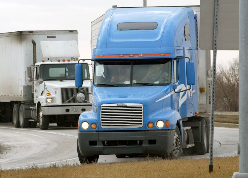 Tractor-trailer trucks on an interstate.