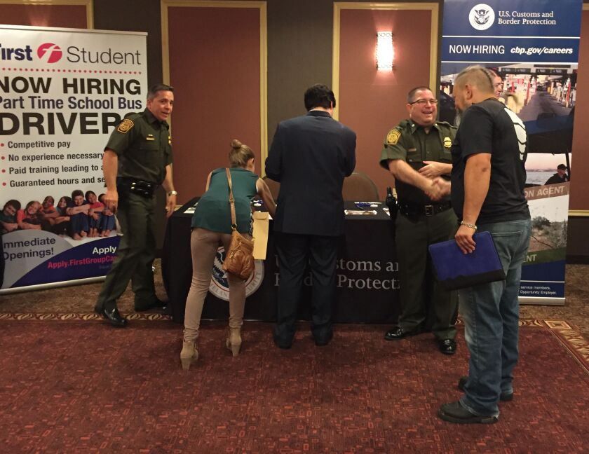 U.S. Border Patrol agents Orlando Ruiz (left) and Bill Burke, shaking hands, were at the Holiday Inn Express in Palatine on Thursday talking to job seekers interested in protecting our country’s southern border. | Neil Steinberg/Sun-Times