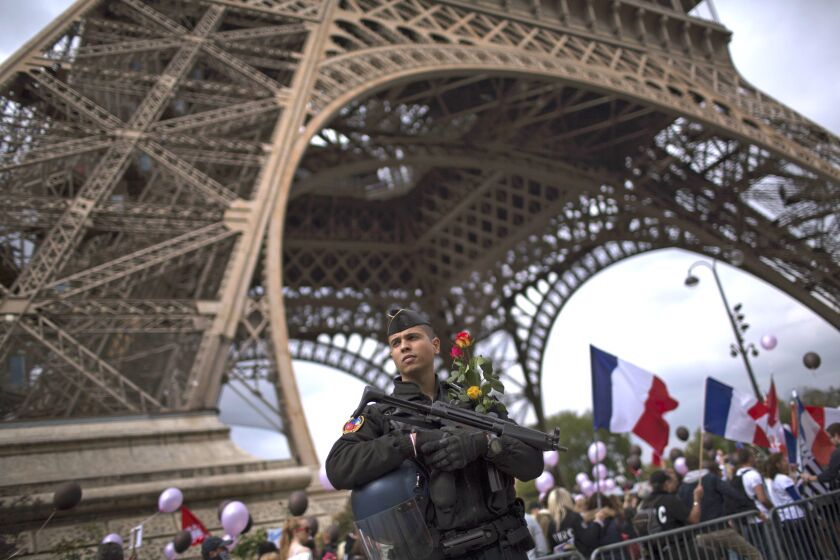 A French riot police officer patrols near the Eiffel Tower as family members of police officers demonstrate in what they described as a march of support for all French security forces. The Saturday march comes just two days after the Champs Elysees attack