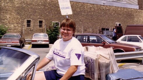 Tracy Baim rides in the 1987 Chicago Pride Parade and hands copies of the gay newspaper Outlines.