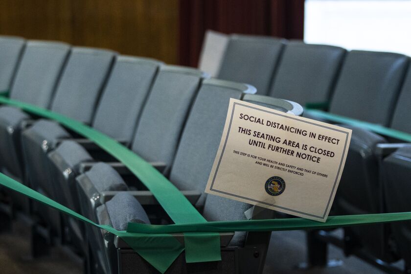 Seats were taped off and marked at the Cook County Board meeting Monday.