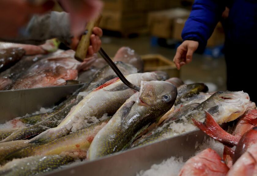 A fishmonger pulls tilefish for a buyer at the New Fulton Fish Market in New York. The U.S. seafood industry is worth $17 billion a year, more than 90 percent of which is from imports. | AP