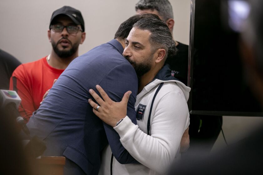 State Rep. Abdelnasser Rashid (21st) embraces Oday Al-Fayoume, father of victim Wadea Al-Fayoume, at a news conference Sunday at the Muslim Community Center, a mosque in Chicago.