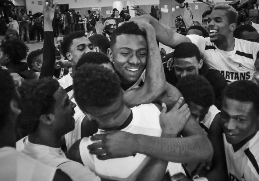 Teammates hug Tyquone Greer after winning a sectional game against Fenwick in 2004.