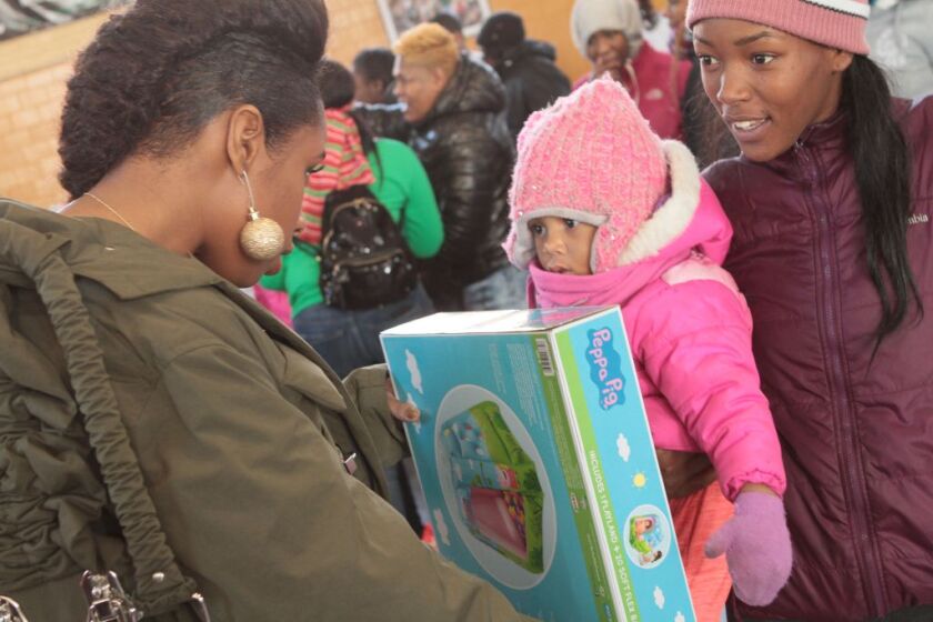 Jennifer Hudson brings some Christmas cheer to a small child during the singer’s 2017 toy drive in Chicago, co-chaired by her sister, Julia Hudson. | Thomas Blue Photography