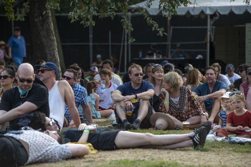 Festival-goers sit in the grass and listen as Waxahatchee performs on the Green Stage at Pitchfork music festival at Union Park, Saturday, Sept. 11, 2021.