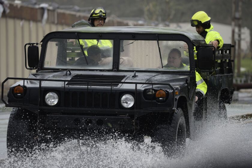Rescue personnel from the Emergency Management Agency drive through a flooded road after Hurricane Maria hit the eastern region of Puerto Rico. | Carlos Giusti/Associated Press