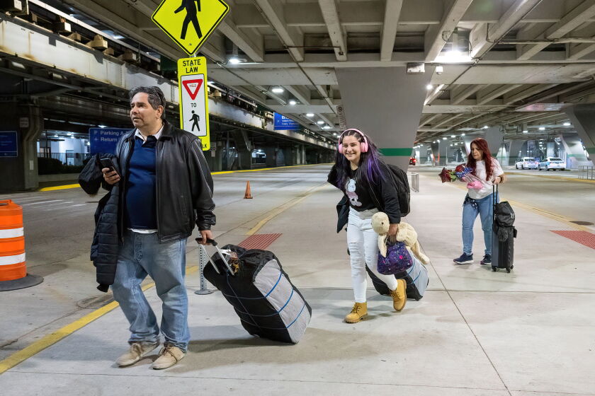 Frank Sandoval, ayuda a su hija Massiel Sandova y esposa Carolina Alemán con su equipaje en el Aeropuerto O'Hare