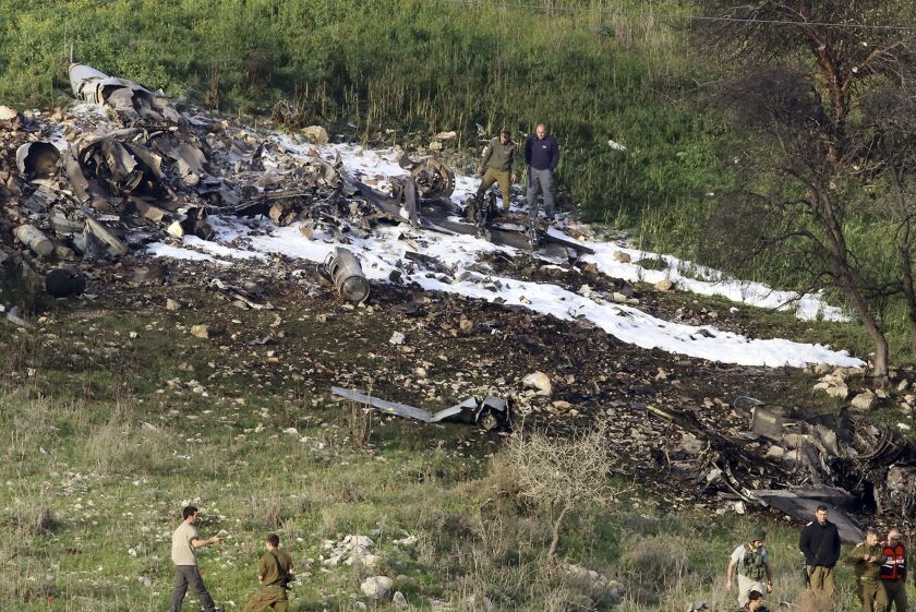 Israeli security stands around the wreckage of an F-16 that crashed in northern Israel, near kibbutz of Harduf on Saturday. | AP photo