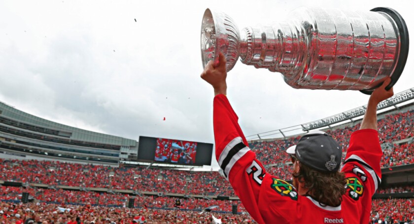 Duncan Keith raises the Stanley Cup in front of a capacity crowd at Soldier Field. | PHOTO COPYRIGHT BLACKHAWKS PUBLISHING