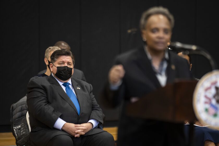 Gov. J.B. Pritzker looks on as Mayor Lori Lightfoot speaks during a news conference at Breakthrough FamilyPlex on the West Side on Monday.