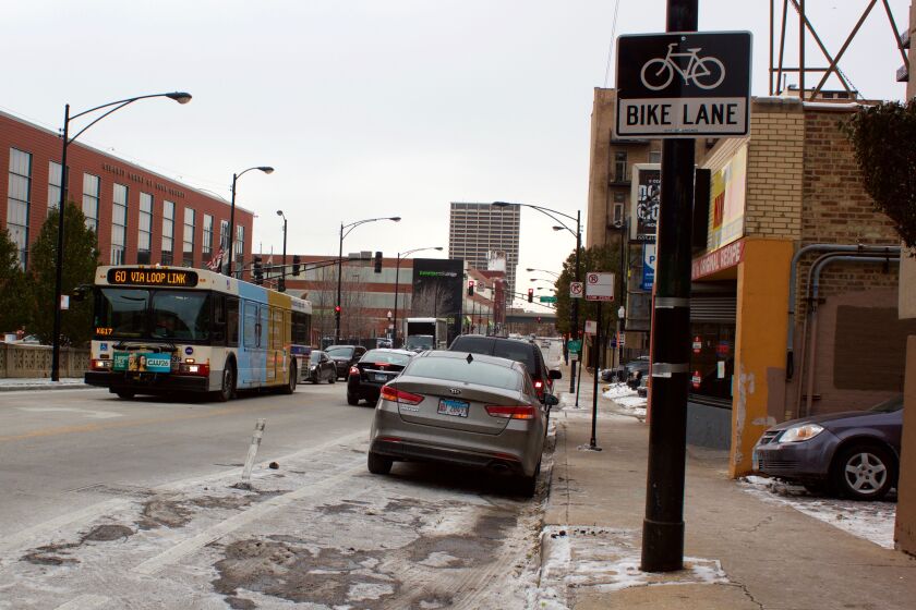 Cars parked in protected bike lanes, like these in the 500 block of West Harrison Street, frustrate cyclists.