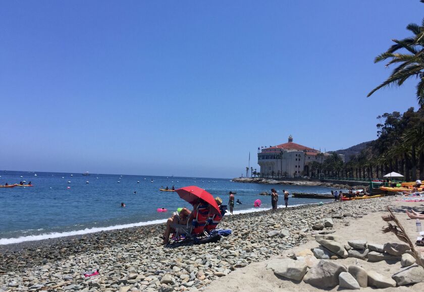This June 22, 2016 photo shows people on the beach at the shore of Catalina Island off the coast of California. The scenic island can be reached by ferry from Long Beach and other points. (AP Photo/Beth J. Harpaz)