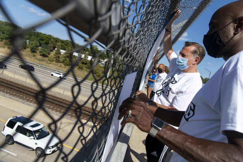 Members of St. Sabina, including Rev. Michael Pfleger (left center, blue mask) protest an a Dan Ryan Expressway overpass at 76th Street on Friday, Aug. 28, 2020.