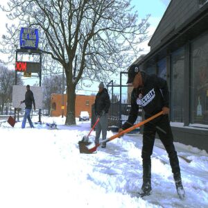 Relatives of the slain security guard, Jemel Roberson, work to clear the deep snow from the front of the closed Manny’s Blue Room Lounge on Saturday. | John Booz/For the Sun-Times