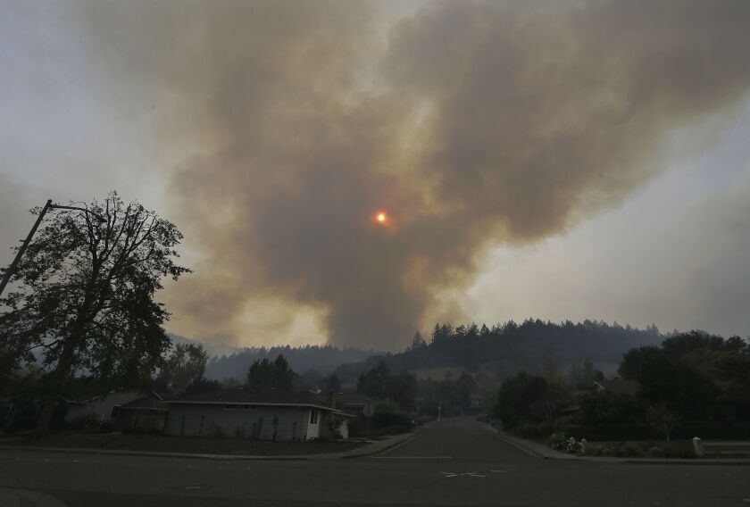 A plume of smoke rises from a mountain over homes in the Oakmont area of Santa Rosa, Calif., on Tuesday. | Jeff Chiu/Associated Press