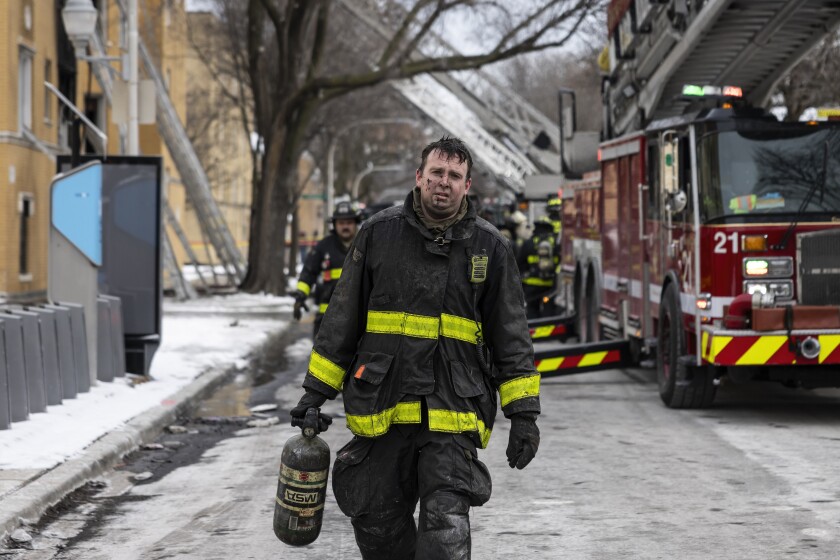 Chicago Fire Department firefighters pack up after extinguishing an extra-alarm fire at an apartment building in the 2700 block of West Granville Avenue in West Ridge on the Northwest Side, Friday, Feb. 14, 2025. A 6-year-old boy was trapped inside the burning building and died, a woman was taken to a hospital in critical condition, and two firefighters were injured while battling the blaze when an indoor stairwell gave out.