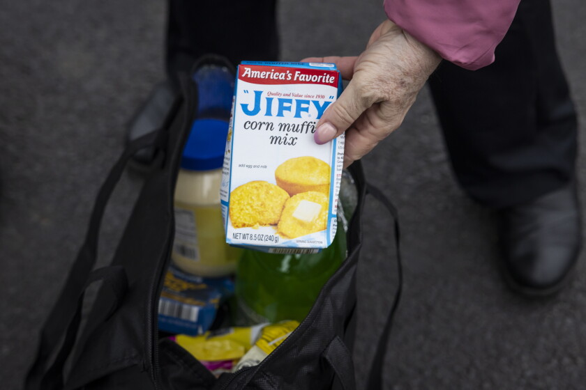 Mary Kay Rosado holds a box of Jiffy corn muffin mix that was in a giveaway bag for the first shoppers at Save A Lot's new West Lawn store.