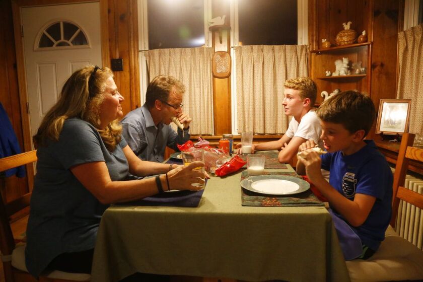 Barb Hailey eats dinner with her husband, Allen, and sons Everett, 15, and Henry, 10, in Chicago. Mealtime is a screen-free zone in their household. | AP Photo