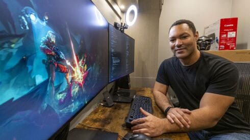 David Barthwell sits in his office next to computer screens with assets from his game Twilight Shift including concept art and code, Friday, Oct. 28, 2022.