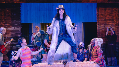 Sean Fortunato (Autolycus, center) is flanked by Patty Roache (Mopsa), Grace Steckler (Dorcas), and the company of Chicago Shakespeare Theater’s production of Shakespeare’s The Winter’s Tale.