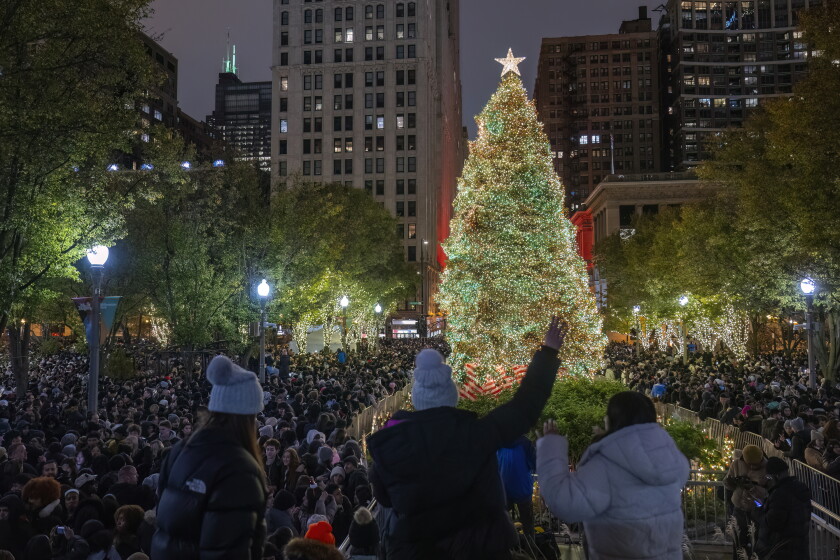 Thousands of people get photos of the fully lit Christmas tree during the 111th Annual Tree Lighting Ceremony at Millennium Park, Friday, Nov. 22, 2024.