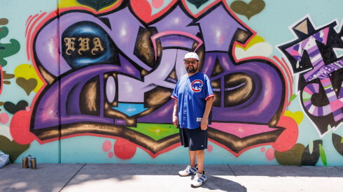 Ole Flores stands in front his graffiti on Green Bay Road in Evanston.