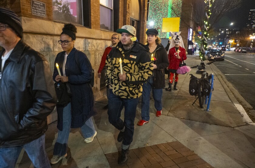 Members of the Sisters of Perpetual Indulgence and others, including Ethan Vazquez (center), march along North Halsted Street with electric candles to commemorate Transgender Day of Remembrance, Thursday, Nov. 20, 2025.