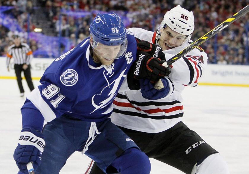 Tampa Bay Lightning center Steven Stamkos (91) battles against Chicago Blackhawks defenseman Kyle Cumiskey (26) during first-period NHL hockey game action in Tampa, Fla., Friday, Feb.27, 2015. | AP Photo/Tampa Bay Times, Dirk Shadd