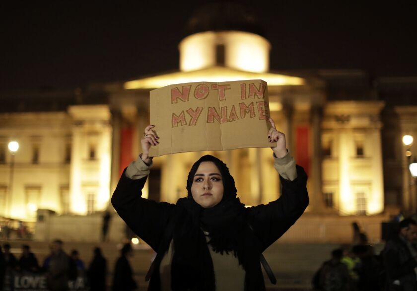 A woman is shown a vigil at Trafalgar Square in London for the victims of Wednesday’s attack. The Islamic State group has claimed responsibility for the attack by a man who plowed an SUV into pedestrians, then stabbed a police officer to death on the grou