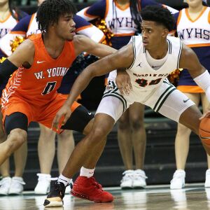 Morgan Park’s Adam Miller (44) works the ball down low as Whitney Young’s Tyler Beard (0) defends.