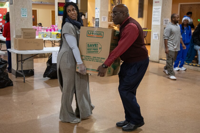 Dr. Amy Jefferson and Terrence Haley carry a box loaded with Christmas dinners at Saint Sabina Church, Thursday, Dec. 25, 2025. | Arthur Maiorella/For the Sun-Times
