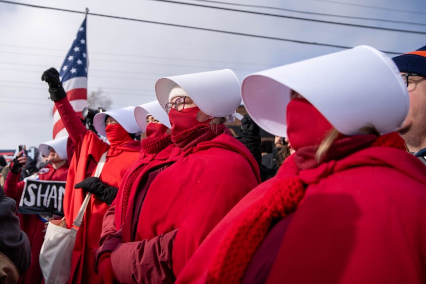 Protesters dressed as characters from "The Handmaid's Tale" appear outside the U.S. Immigration and Customs Enforcement facility in Broadview on Saturday.