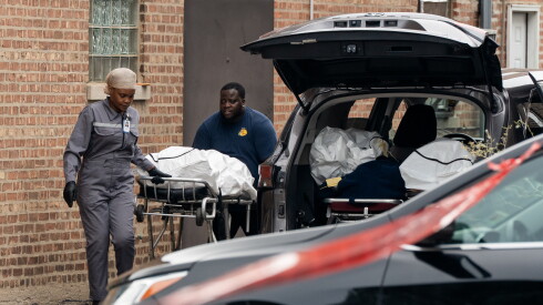 Workers load bodies into an SUV outside South Chicago Chapel in South Deering on the Far South Side, Friday, Aug. 7, 2026, after 56 decomposing bodies were found in South Chicago Chapel, a funeral home, the night before.