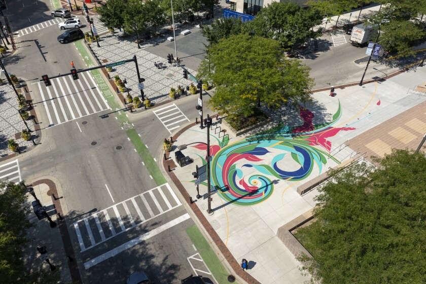 An overheard photograph shows a swirling mural on the ground at the corner of Orrington Avenue and Davis Street in Evanston.